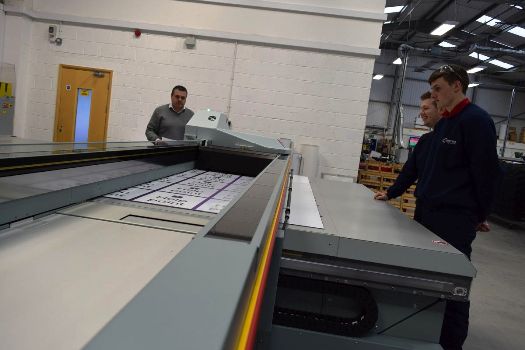 Leroy Fox, Sales Director of Contract Sign Systems (left) and two employees watch the new Océ Arizona 6160 XTS in action 